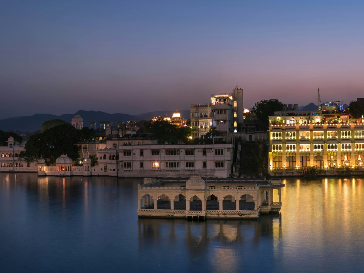 white concrete building near body of water during night time