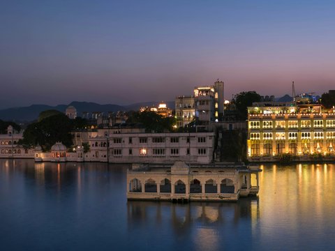 white concrete building near body of water during night time