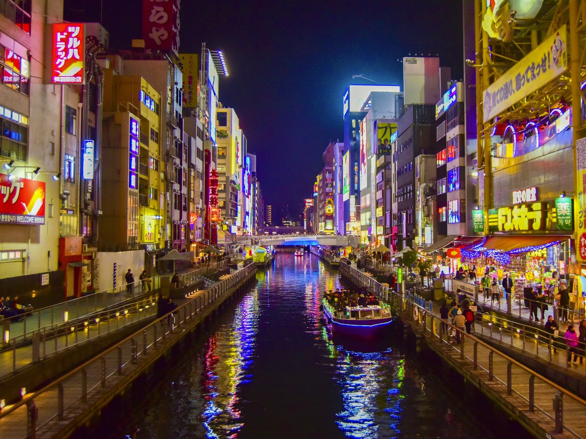 boat on river between high rise buildings during nighttime