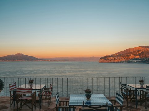 a table and chairs with a view of the ocean