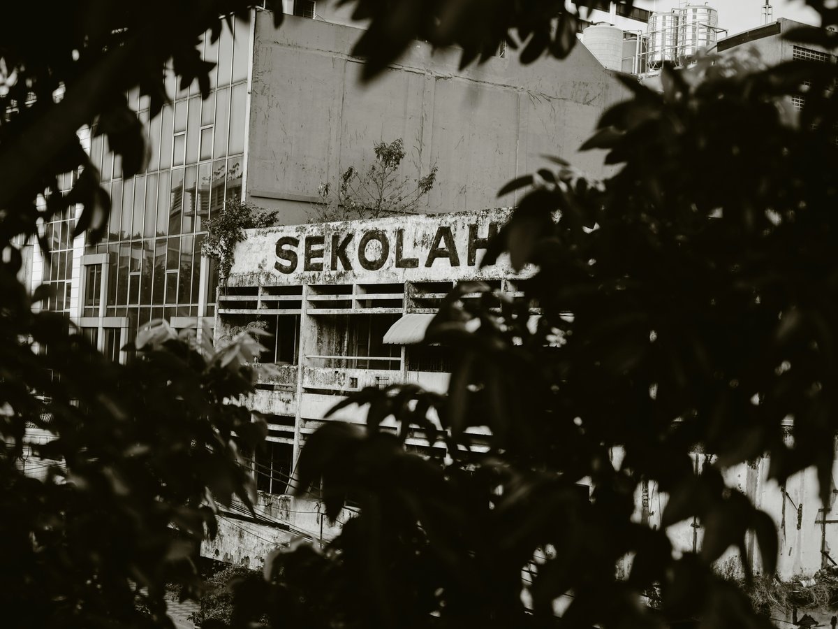 a black and white photo of a building with a sign on it