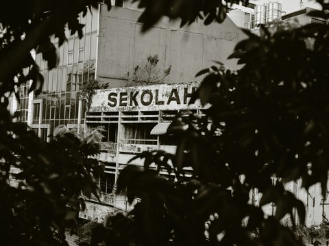 a black and white photo of a building with a sign on it