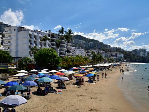 Beach with umbrellas, hotels, and people enjoying the sun