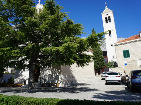 White church building with bell tower and cars