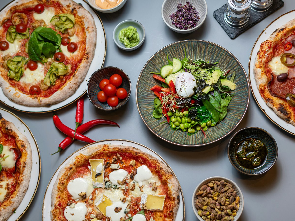 A table topped with lots of different types of pizza