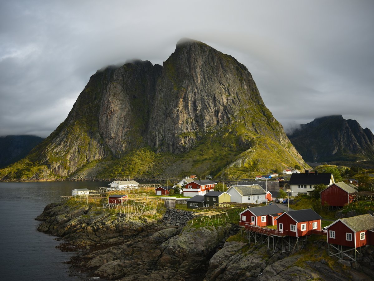 a small village on a small island with a mountain in the background