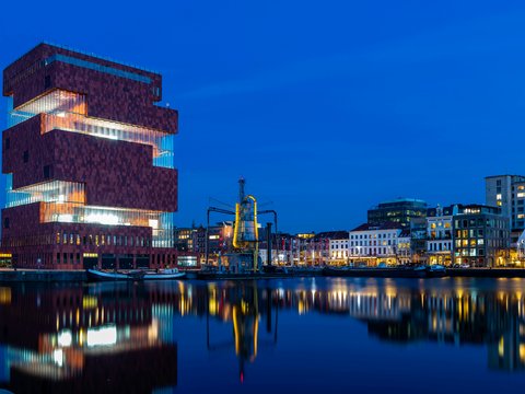 brown concrete building near body of water during night time