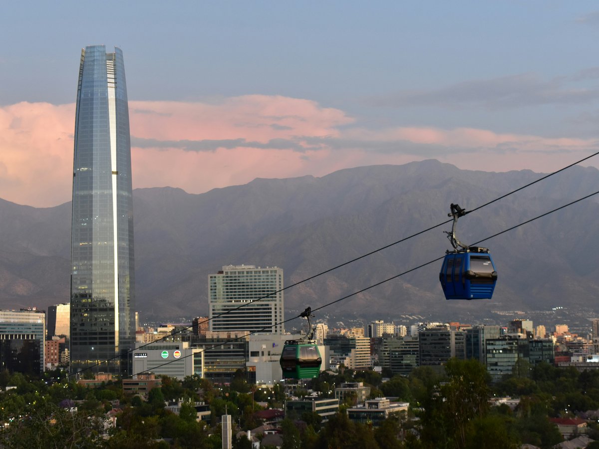 Modern skyscrapers and cable cars in a city with mountains