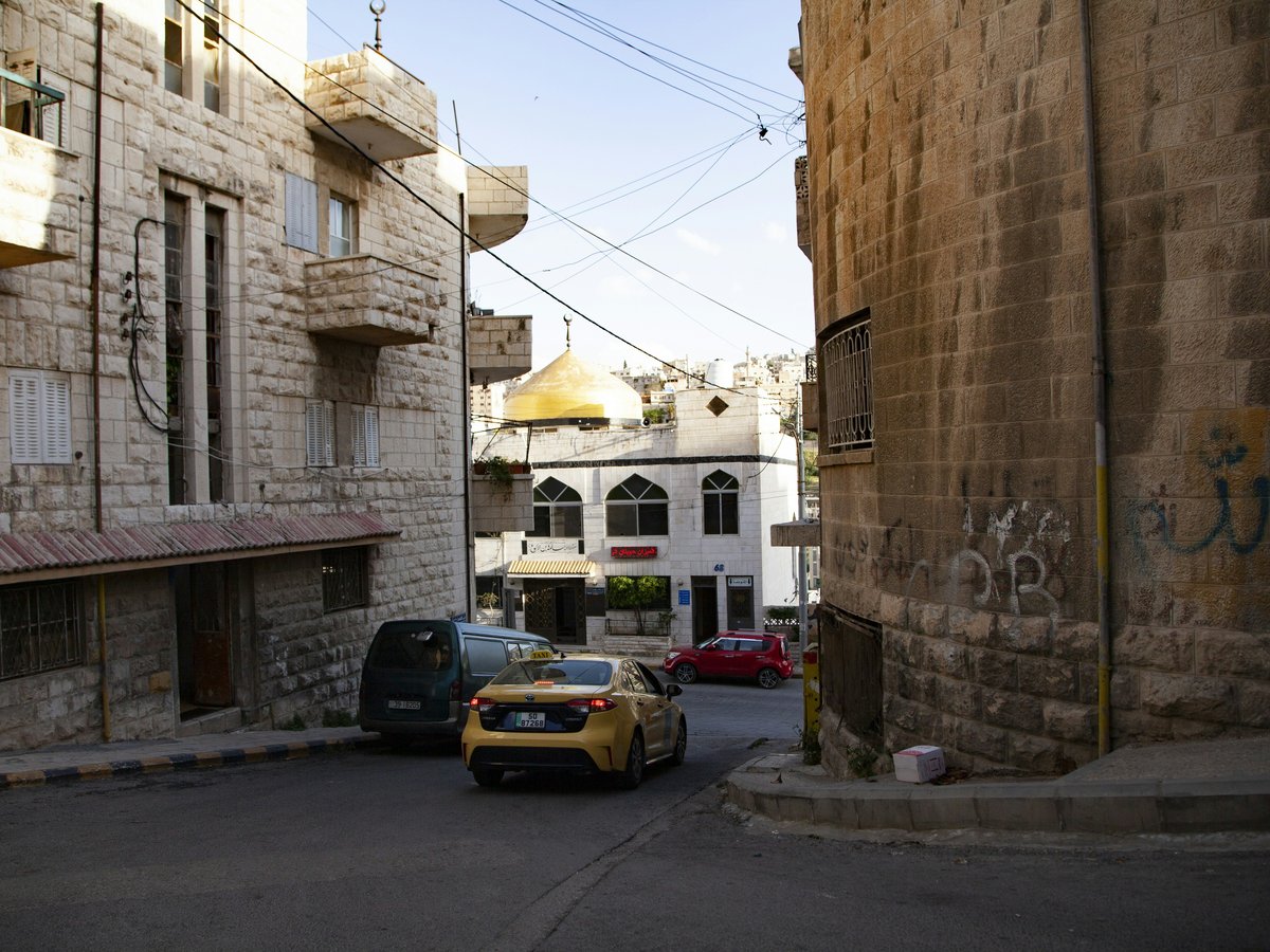 a car parked on the side of a road next to a building