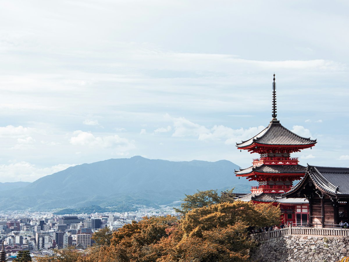 a tall red building sitting on top of a lush green hillside