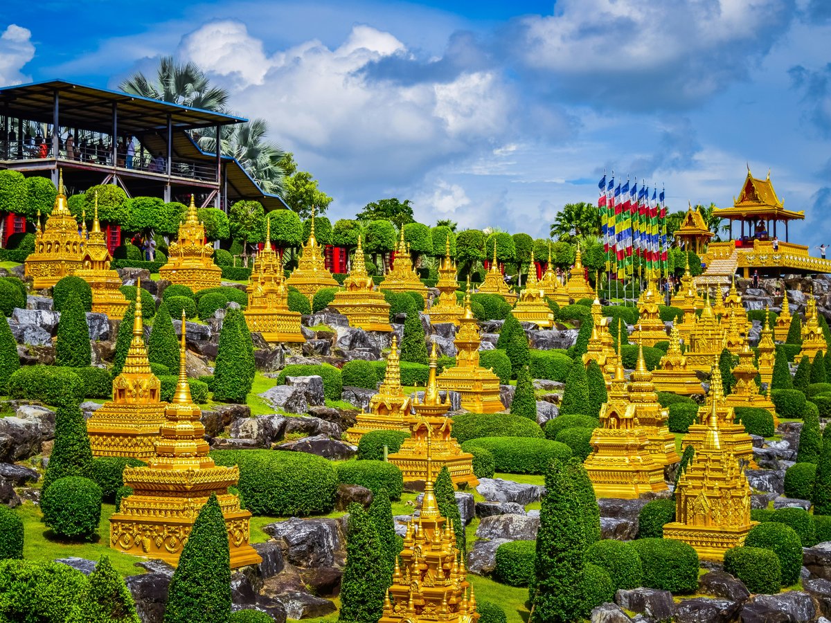 a large group of yellow statues in a garden