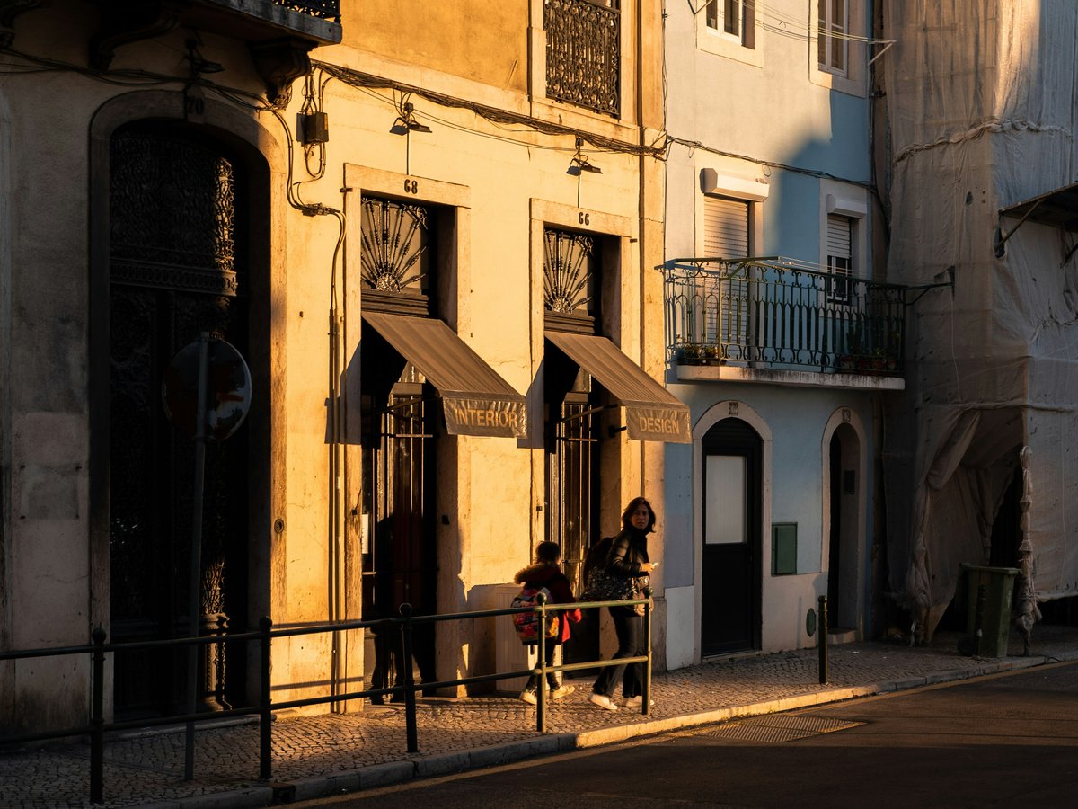 a couple of people sitting on a bench in front of a building