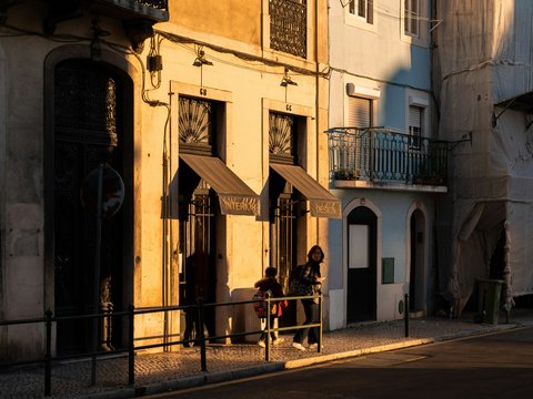 a couple of people sitting on a bench in front of a building