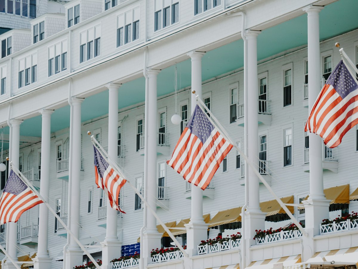 a row of american flags flying in front of a hotel