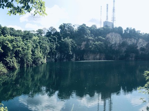 a lake surrounded by trees with a radio tower in the background