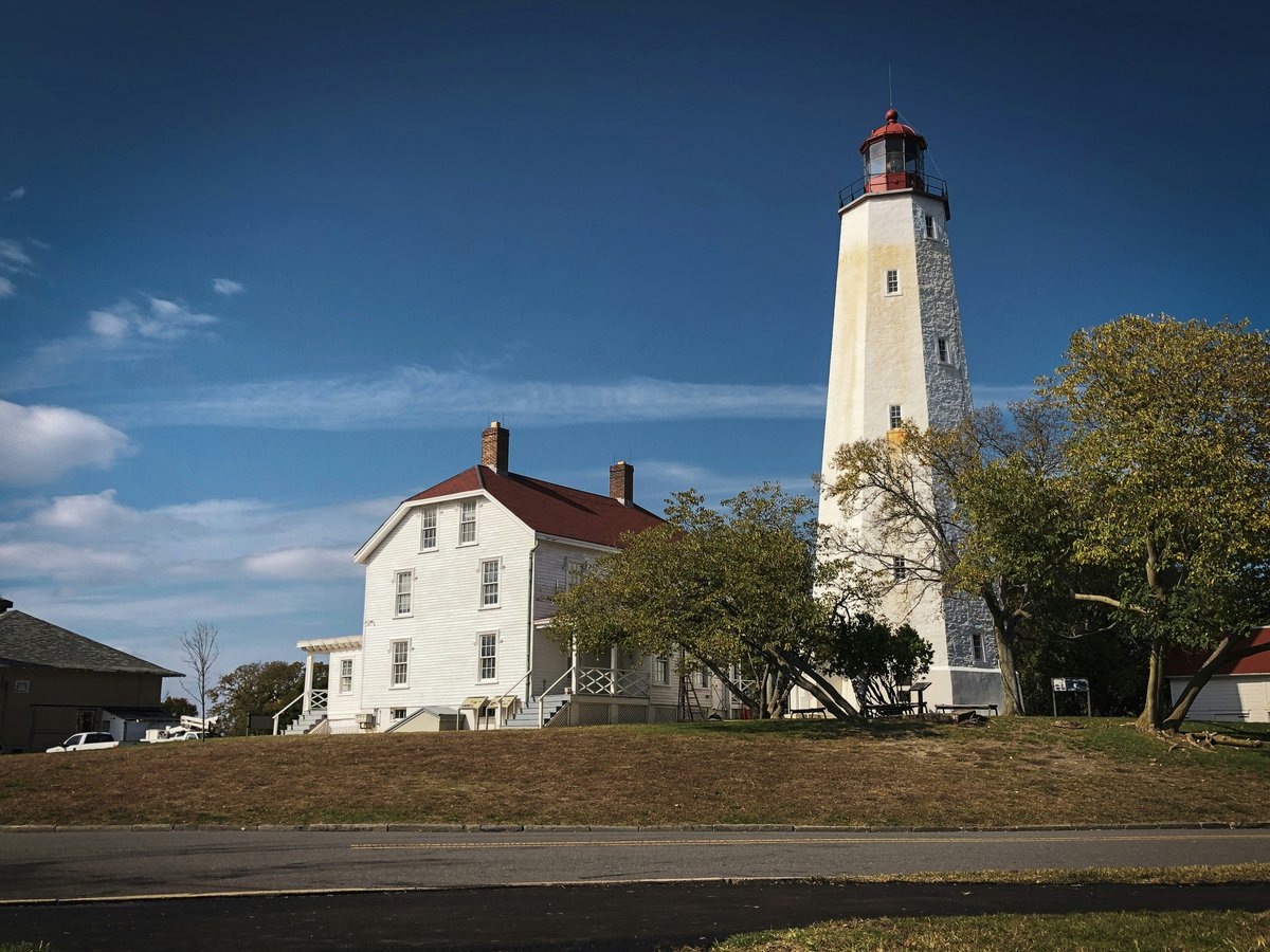 a white house with a red roof and a light tower