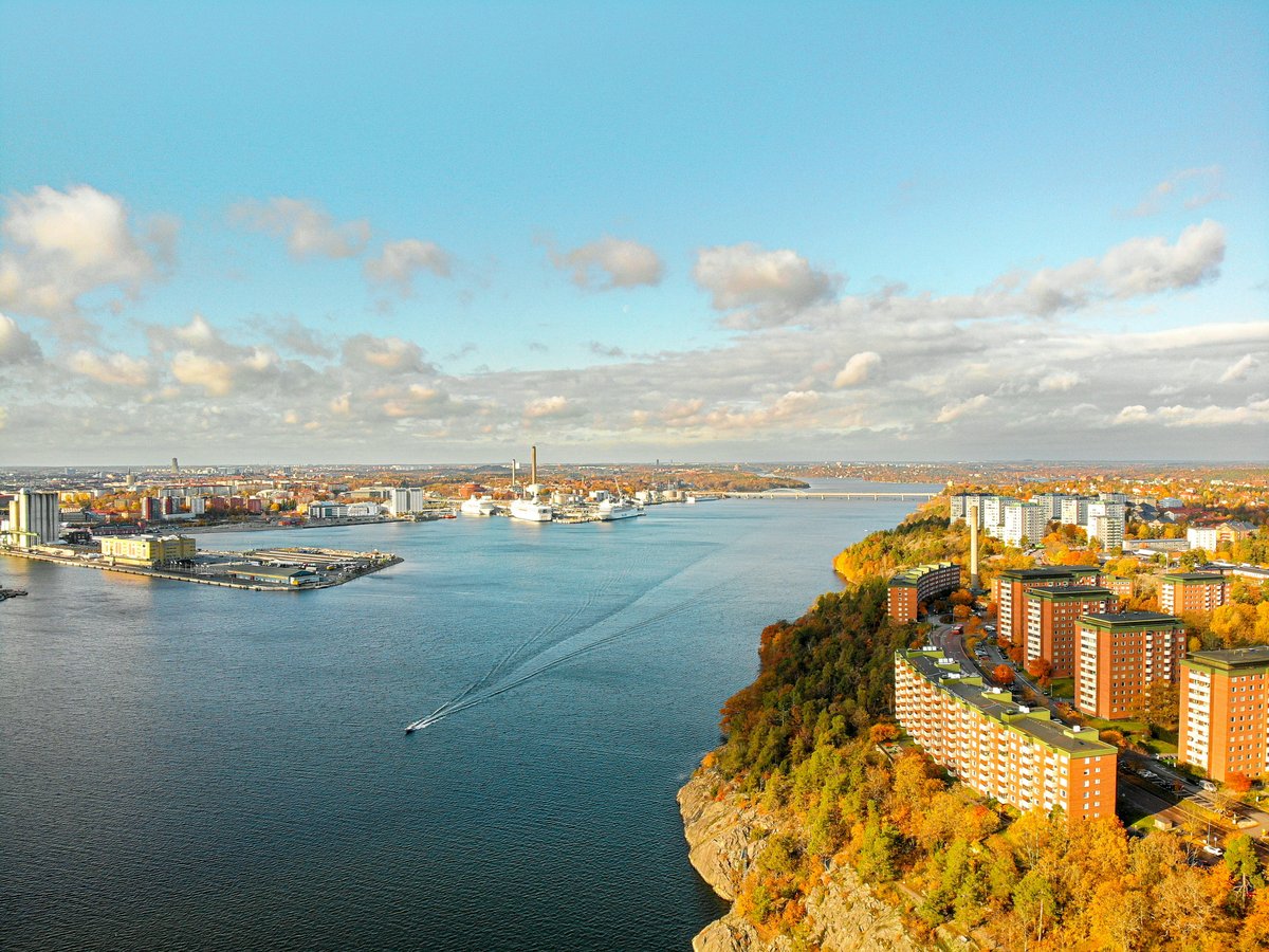 aerial photography of city with high-rise buildings viewing blue sea under white and blue sky during daytime