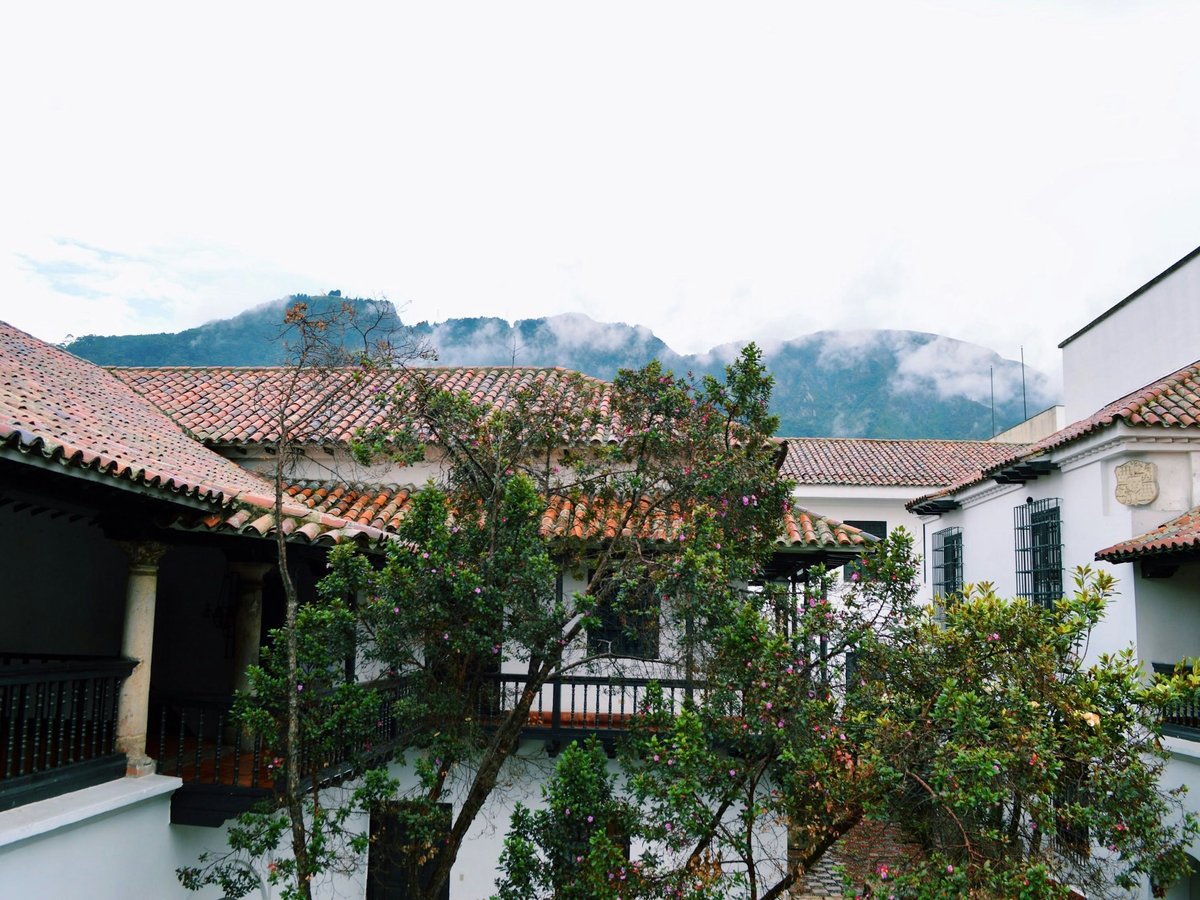 white and brown concrete house near green trees during daytime