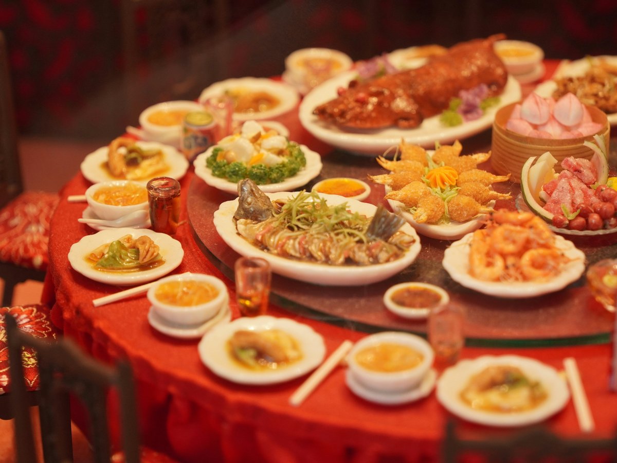 Table laden with diverse asian dishes and roasted pig