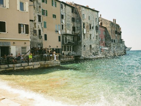 Historic buildings by the sea with waves splashing