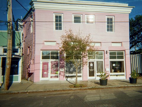 A pink building stands on a city street