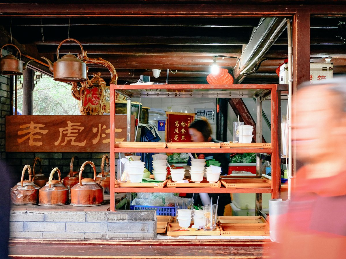 a man standing in front of a store filled with items