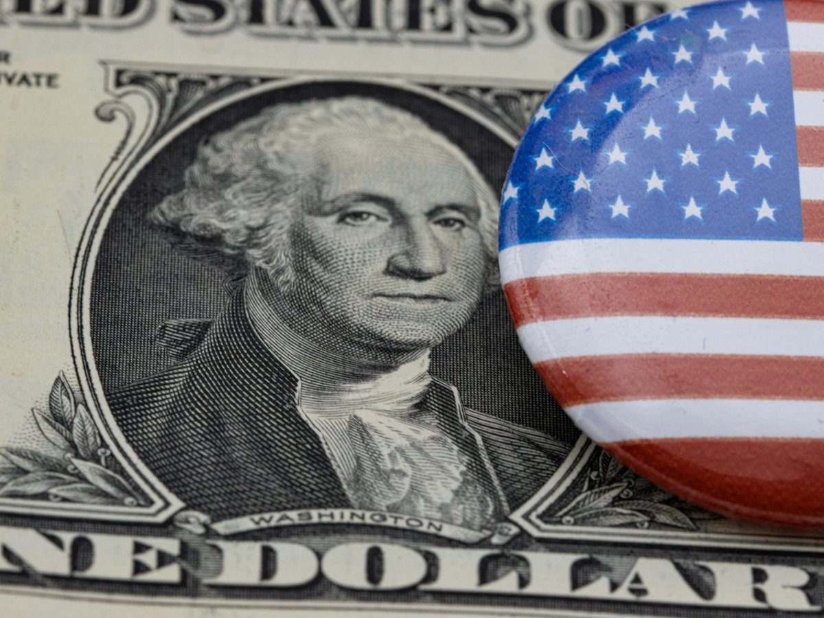 a close up of a one dollar bill and a button