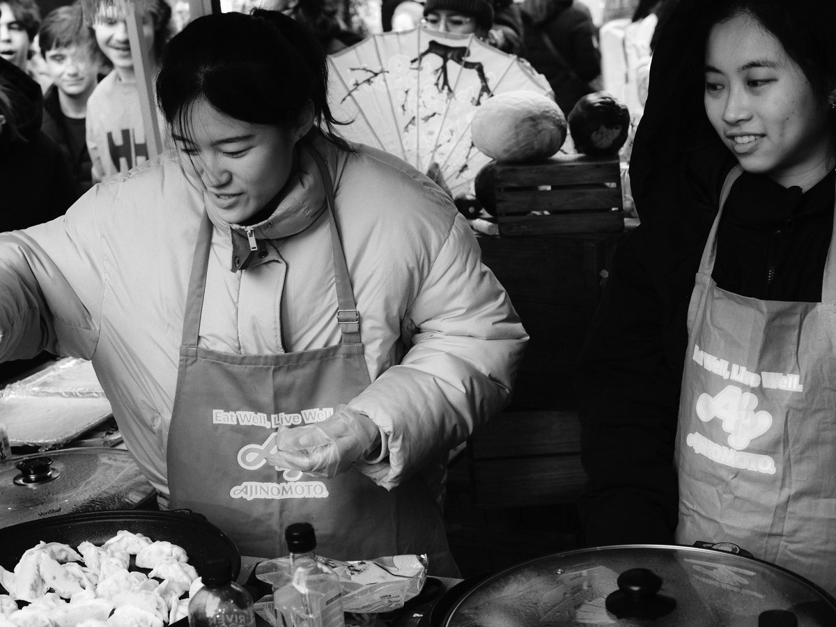 Two women preparing food at a market stall