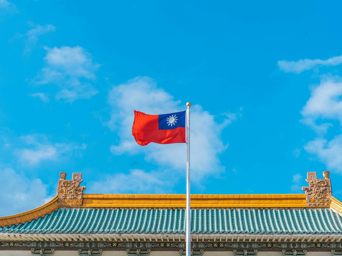 a red and blue flag on top of a building