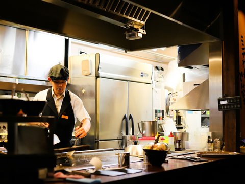 man in white dress shirt standing in front of kitchen sink