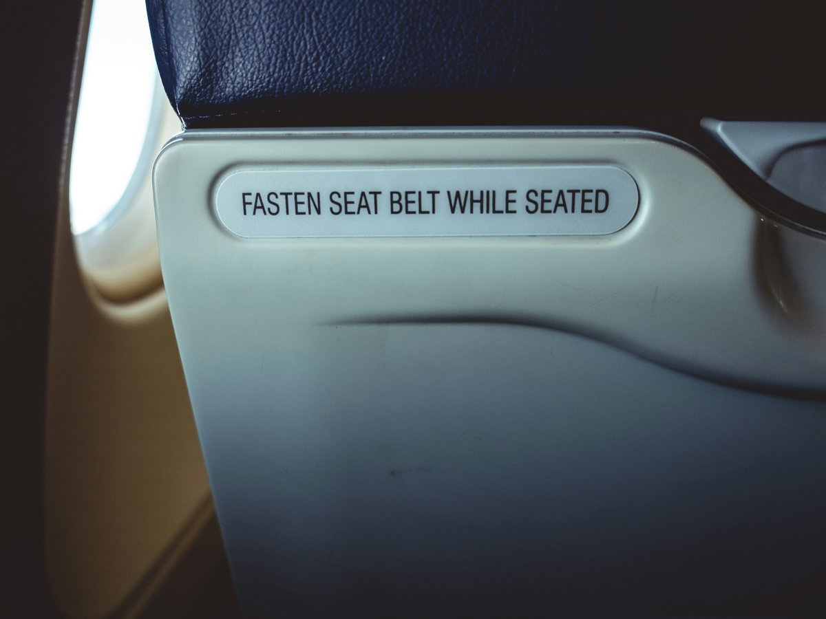 a seat with a sign that says fasten seat belt while seated