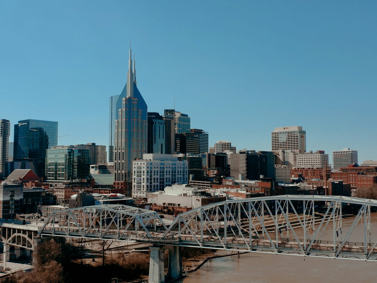 a bridge over a river with a city in the background