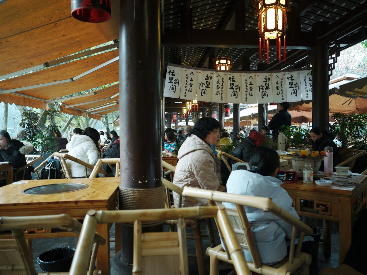 A group of people sitting at tables under umbrellas