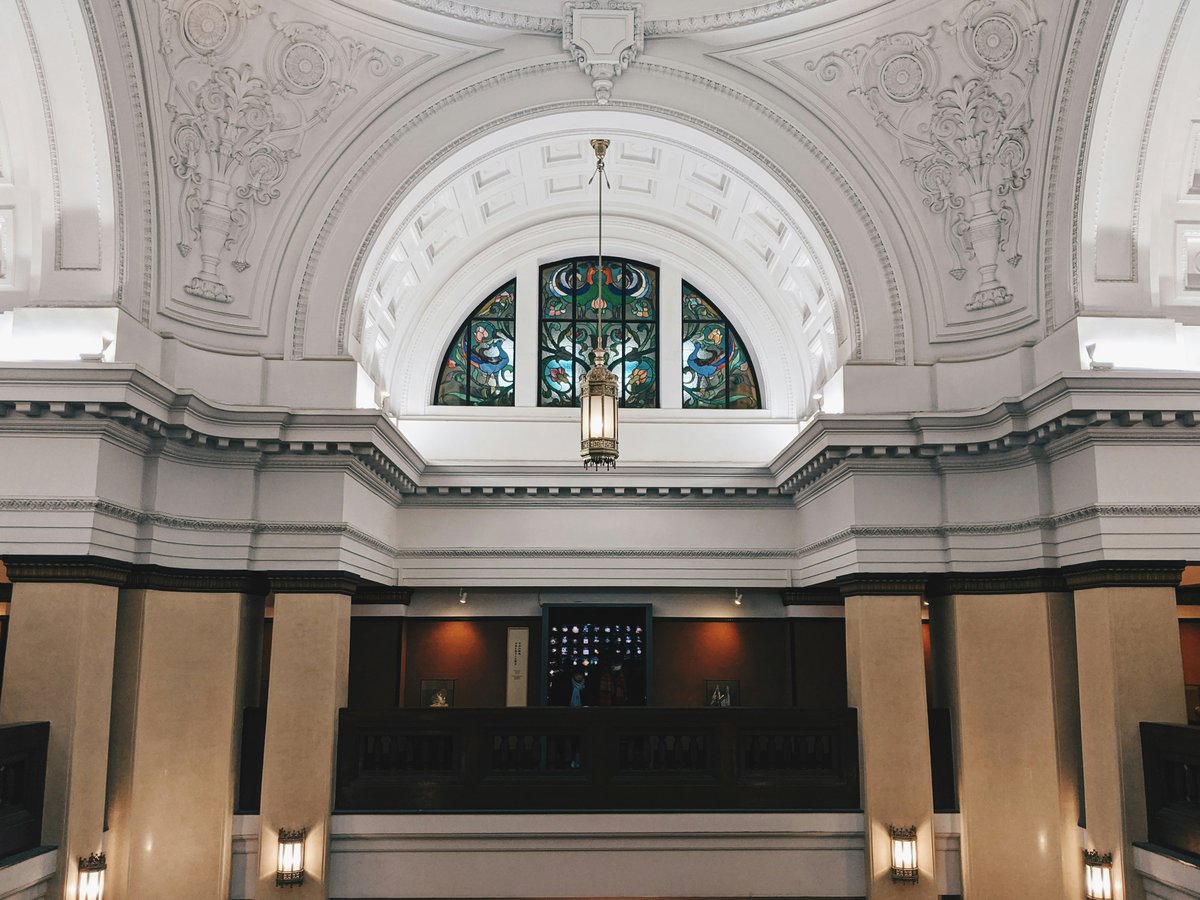 the inside of a large building with a chandelier and stained glass windows