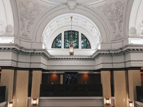 the inside of a large building with a chandelier and stained glass windows