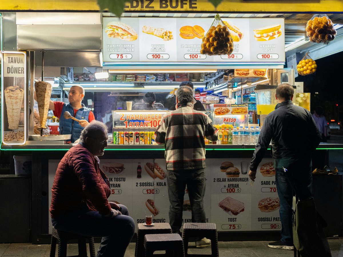 a group of people standing in front of a food stand