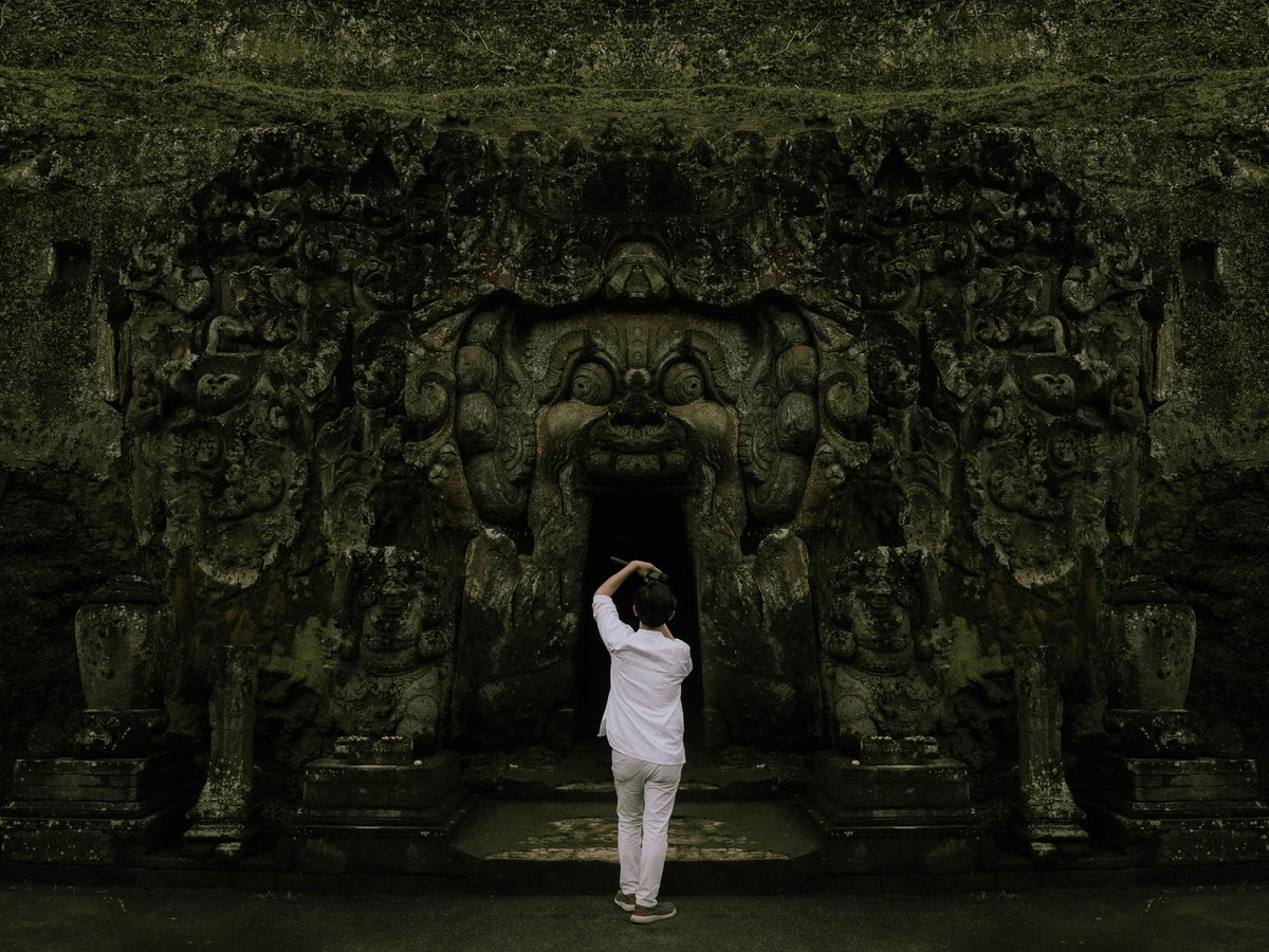 a person standing in front of a stone wall