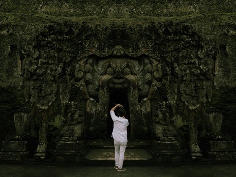 a person standing in front of a stone wall