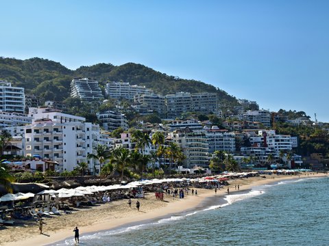 Beachfront buildings line a sunny coast