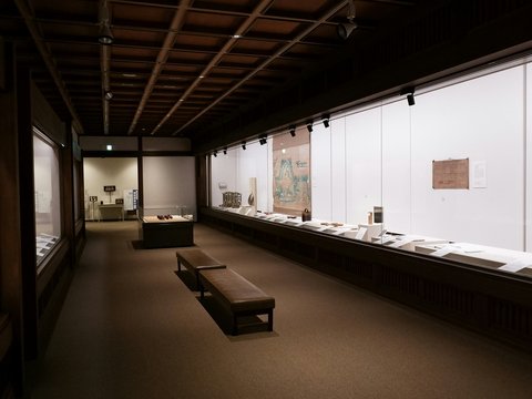 An art gallery hallway with displays and benches.