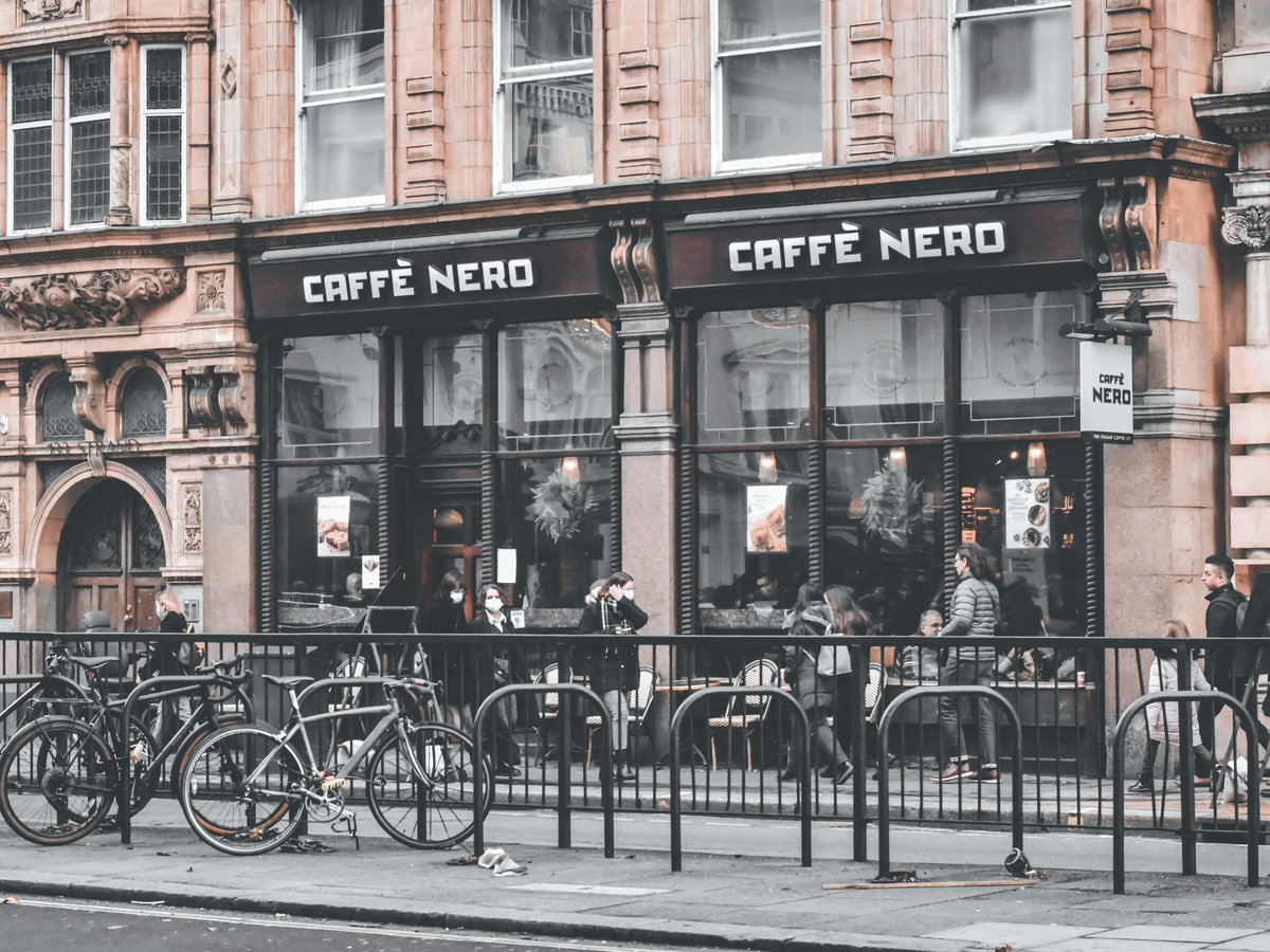 a row of bikes parked in front of a coffee shop