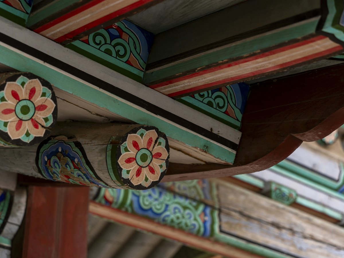 a close up of a wooden structure with flowers painted on it
