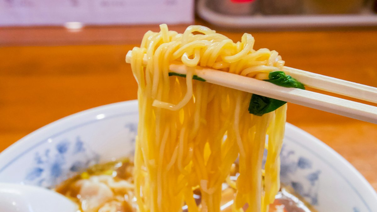 A steaming bowl of Tokyo-style shoyu ramen crowned with a jammy ajitama egg, nori, bamboo shoots and scattered scallions glistening in the lamp-warm broth
