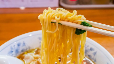 A steaming bowl of Tokyo-style shoyu ramen crowned with a jammy ajitama egg, nori, bamboo shoots and scattered scallions glistening in the lamp-warm broth