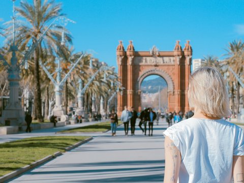 woman standing on road near concrete arch at daytime
