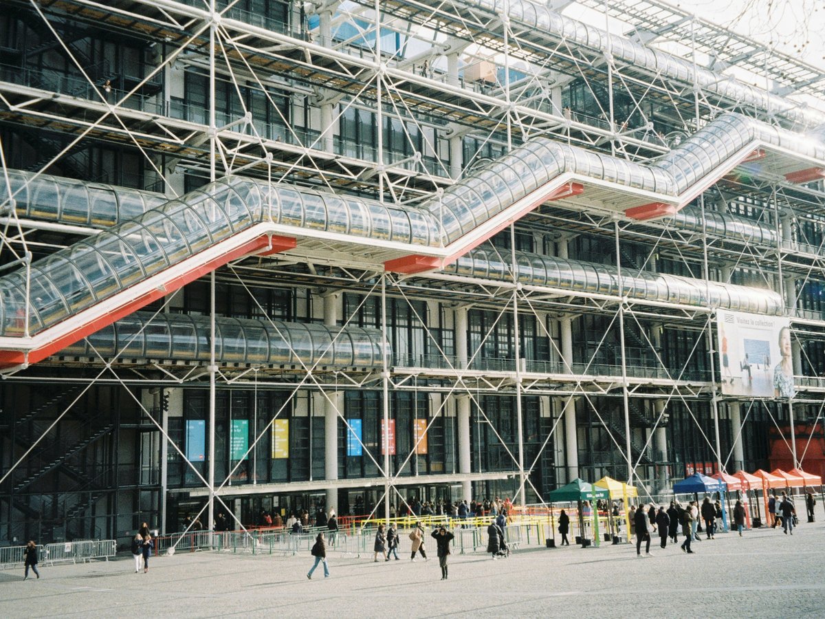 A group of people walking in front of a large building