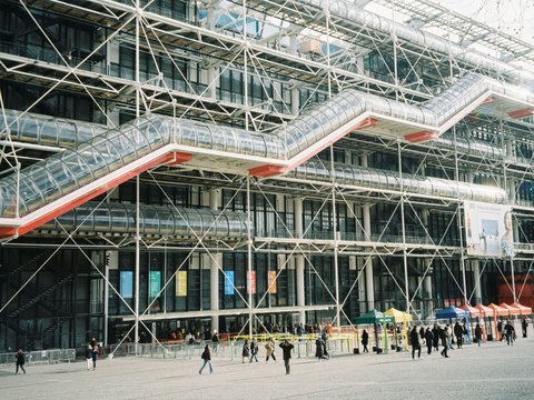 A group of people walking in front of a large building