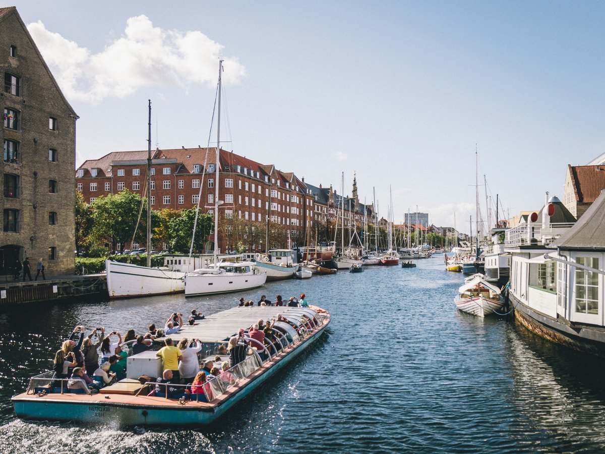people riding on boat on water near buildings during daytime