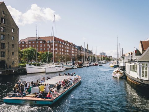 people riding on boat on water near buildings during daytime