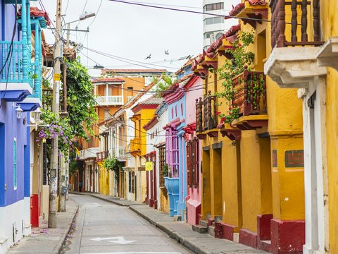 a narrow city street lined with colorful buildings